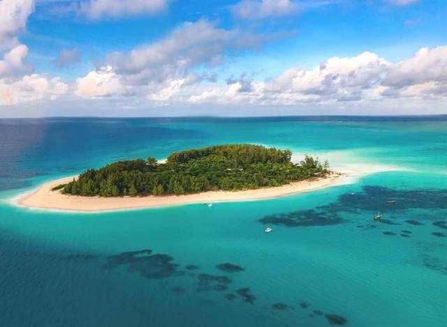 Aerial view of Mnemba Island off Zanzibar ringed by a turquoise reef