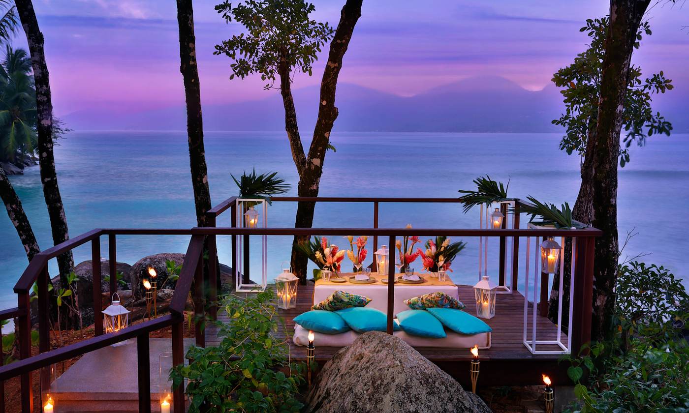 Candlelit dinner for two on a seaside deck at dusk