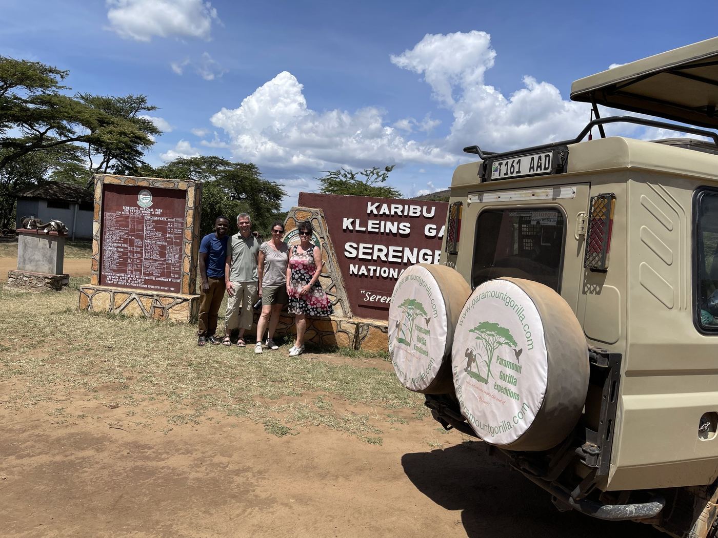 Guests standing at the Klein's Gate entrance sign for Serengeti National Park